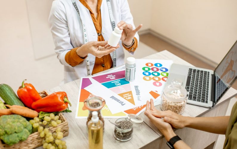 Nutrición Cecilia León dando unas pastillas saludables vitamínicas a un cliente